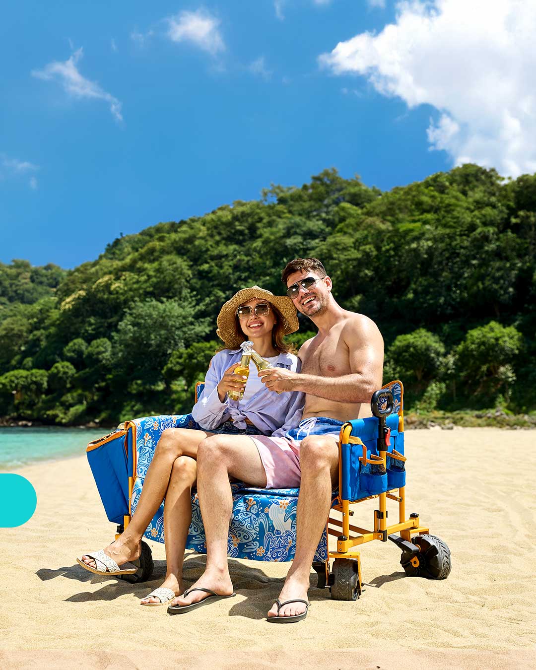 Two people sitting on a Portal Outdoors's beach wagon by the ocean
