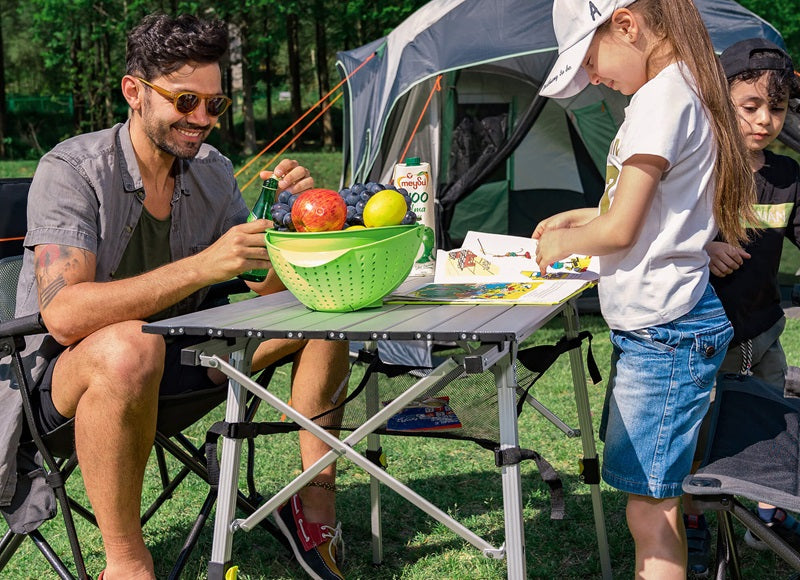 Portable camping table set up at campsite for outdoor use